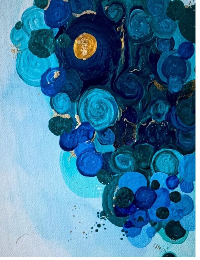Macro detail of clustered cobalt circles on cream canvas, gold thread visible