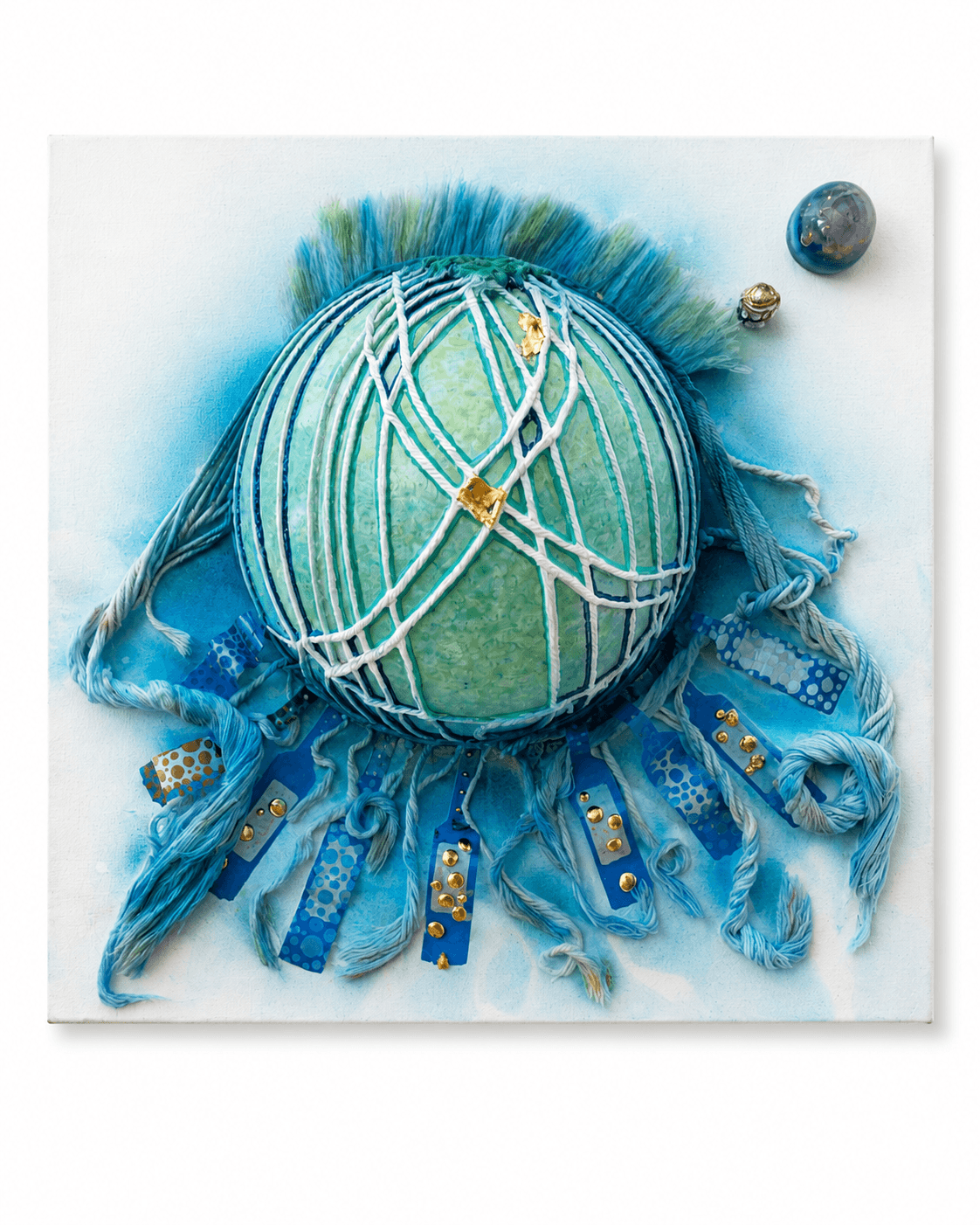 Jellyfish by Victoria Zeder — green-teal sphere wrapped in white thread netting with blue thread fringe and gold beads